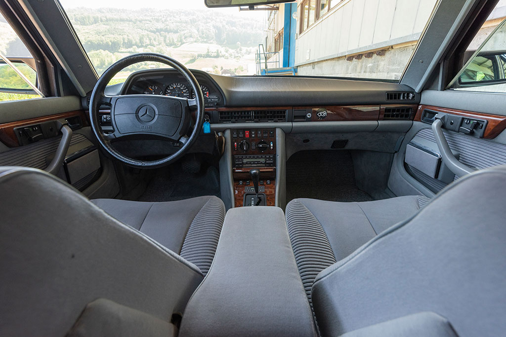 Mercedes-Benz 560 SEL - L'espace avant est séparé par une console centrale imposante.